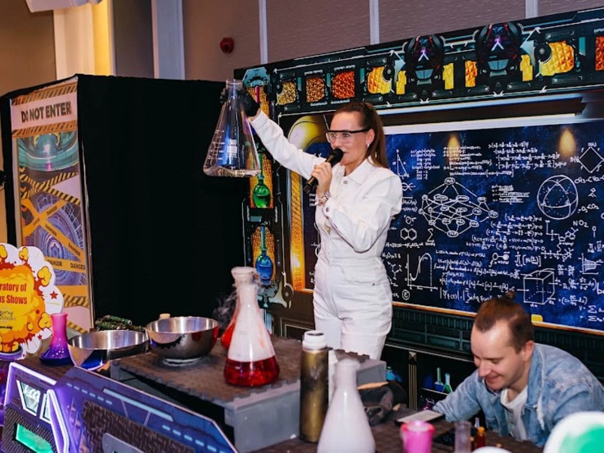 Chemical decorations for a birthday party and a woman with a test tube.