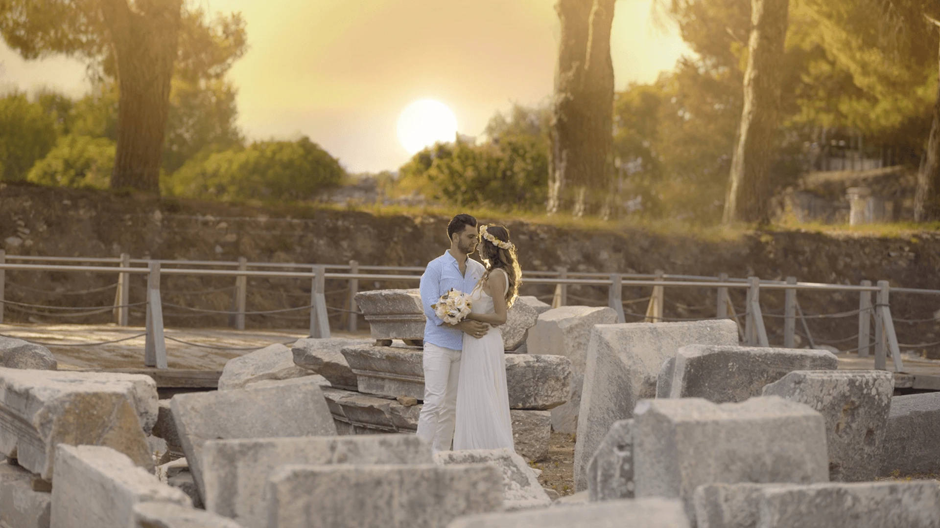 Outdoor wedding ceremony in Cyprus during October golden hour, with warm low-angle light and Mediterranean coastline in the background.