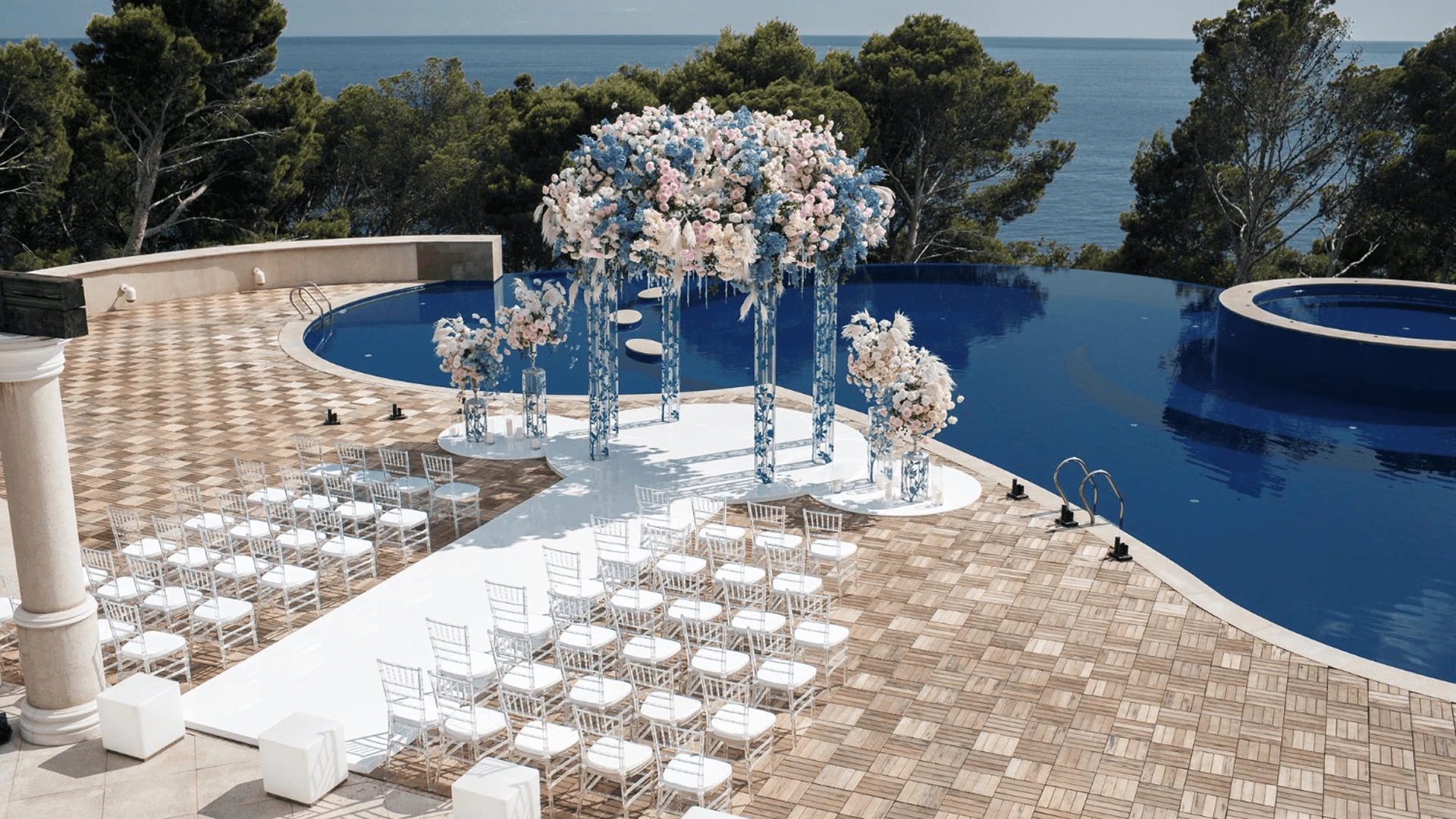 Outdoor private villa wedding reception featuring a long banquet table and custom overhead string lighting in Cyprus.