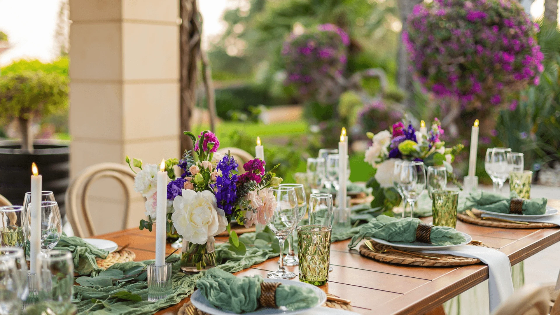 Elegant outdoor dinner table set with candles and flowers at a garden event venue in Cyprus