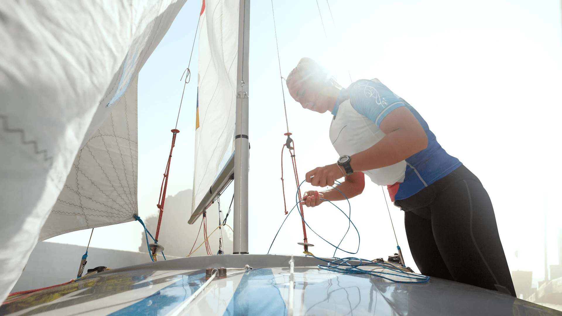 Woman rigging ropes on a sailing dinghy during a regatta team building activity in Cyprus