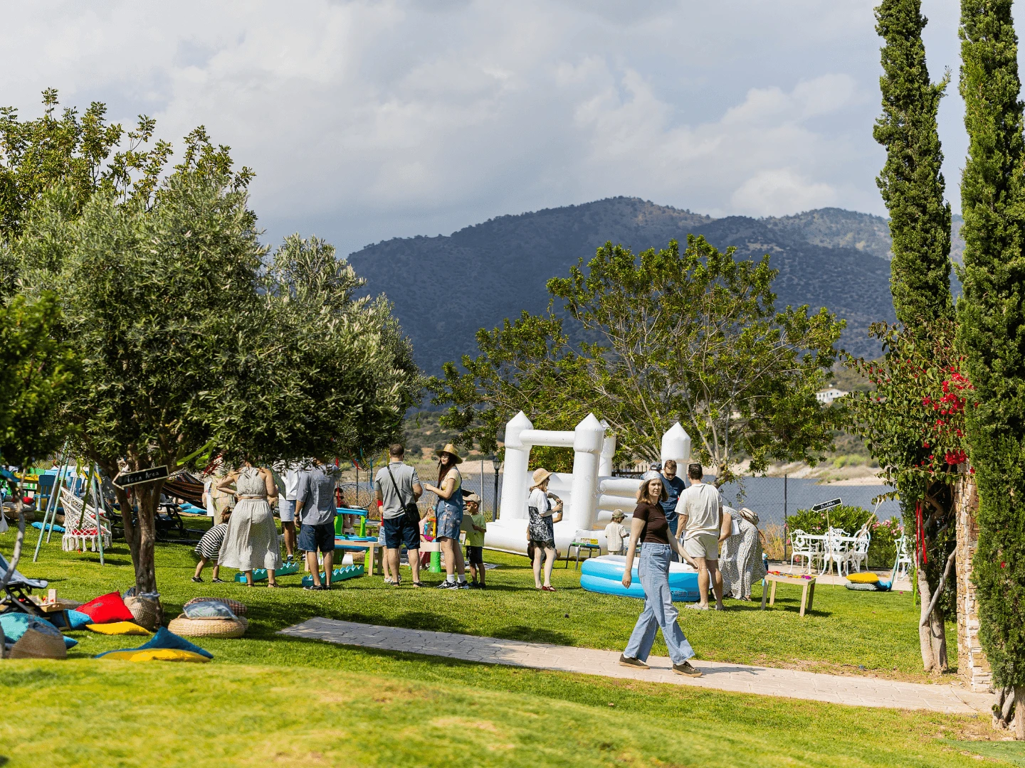 Company group at an outdoor lakeside party with games and a bouncy castle below the Troodos mountains in Cyprus