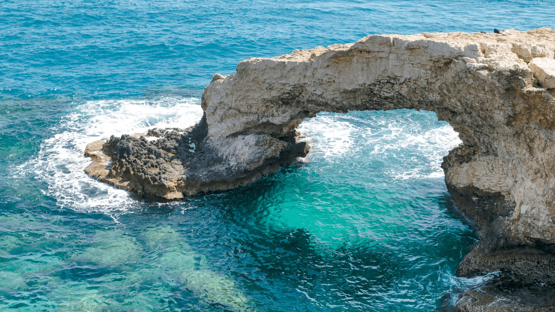 Natural sea arch over turquoise water at Cape Greco, a popular yacht swim stop in Cyprus