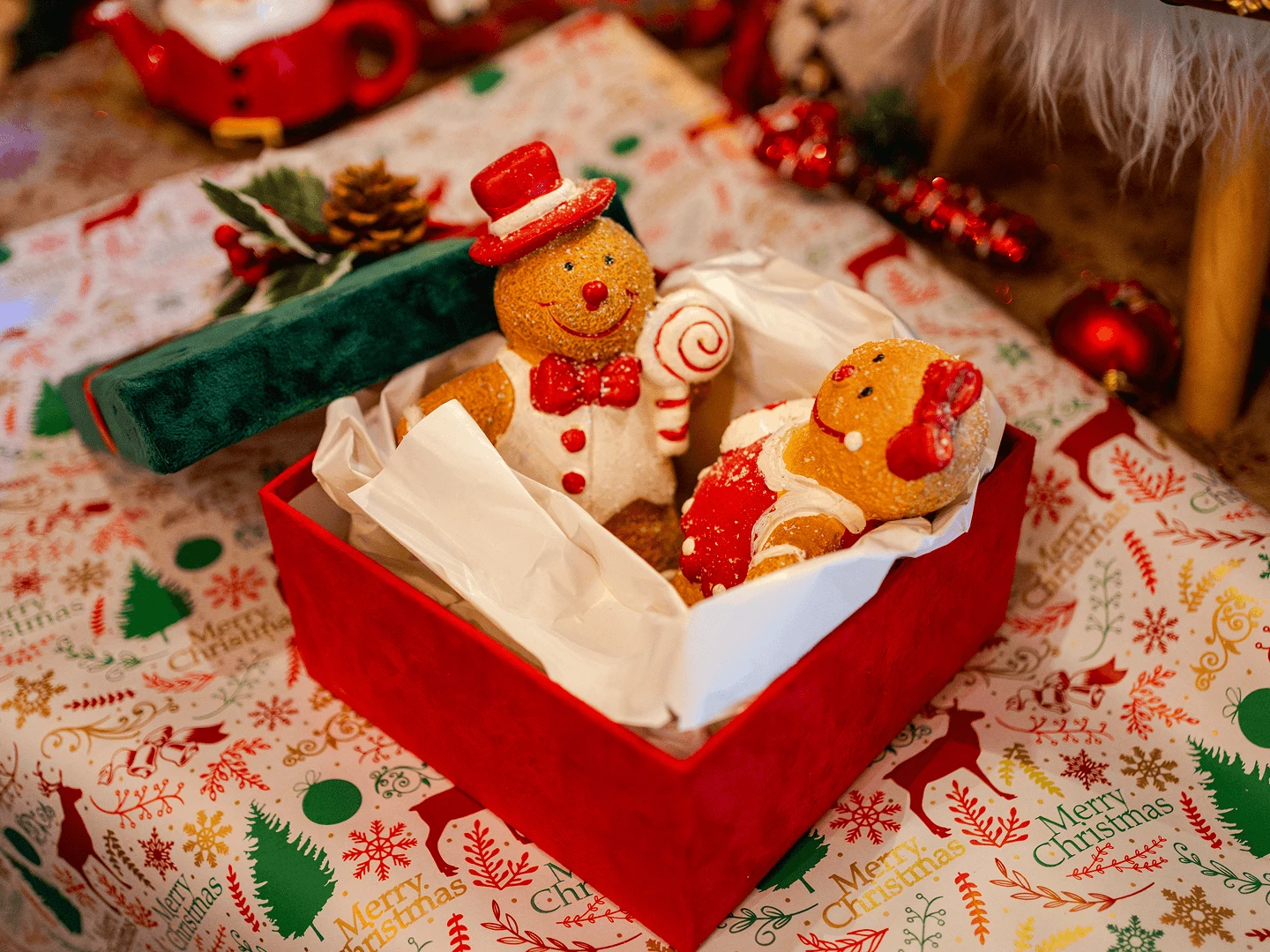 Gingerbread figures packed in a red gift box on festive wrapping paper