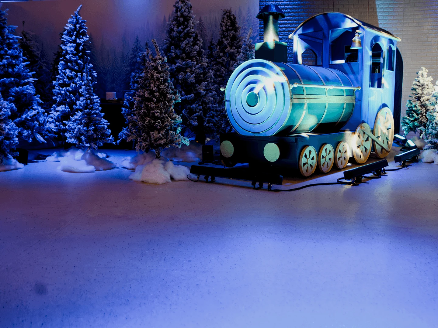 Синий паровоз среди заснеженных ёлок в декорации Winter Wonderland на новогоднем корпоративе на Кипре